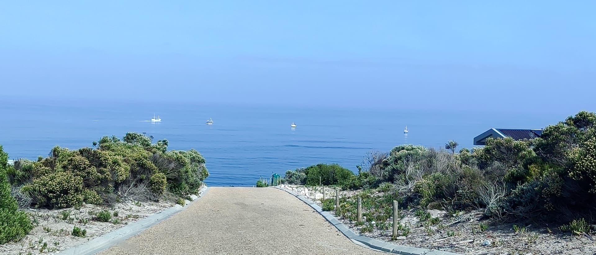 The Overberg coastline near Gansbaai, fishing boats on a calm sea — Happy Homes' service area