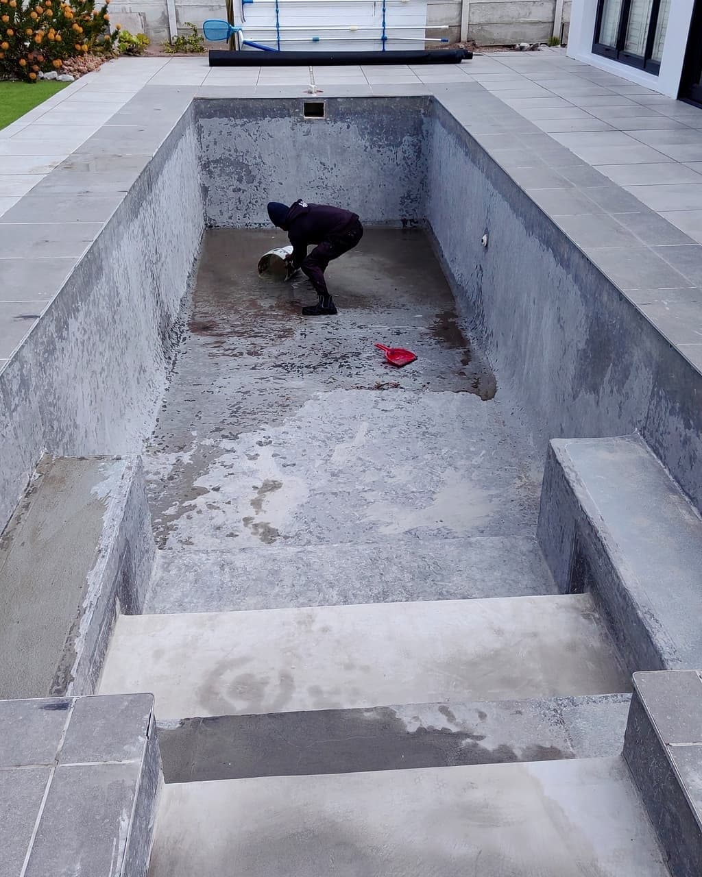 Pool before revamp — bare grey concrete shell