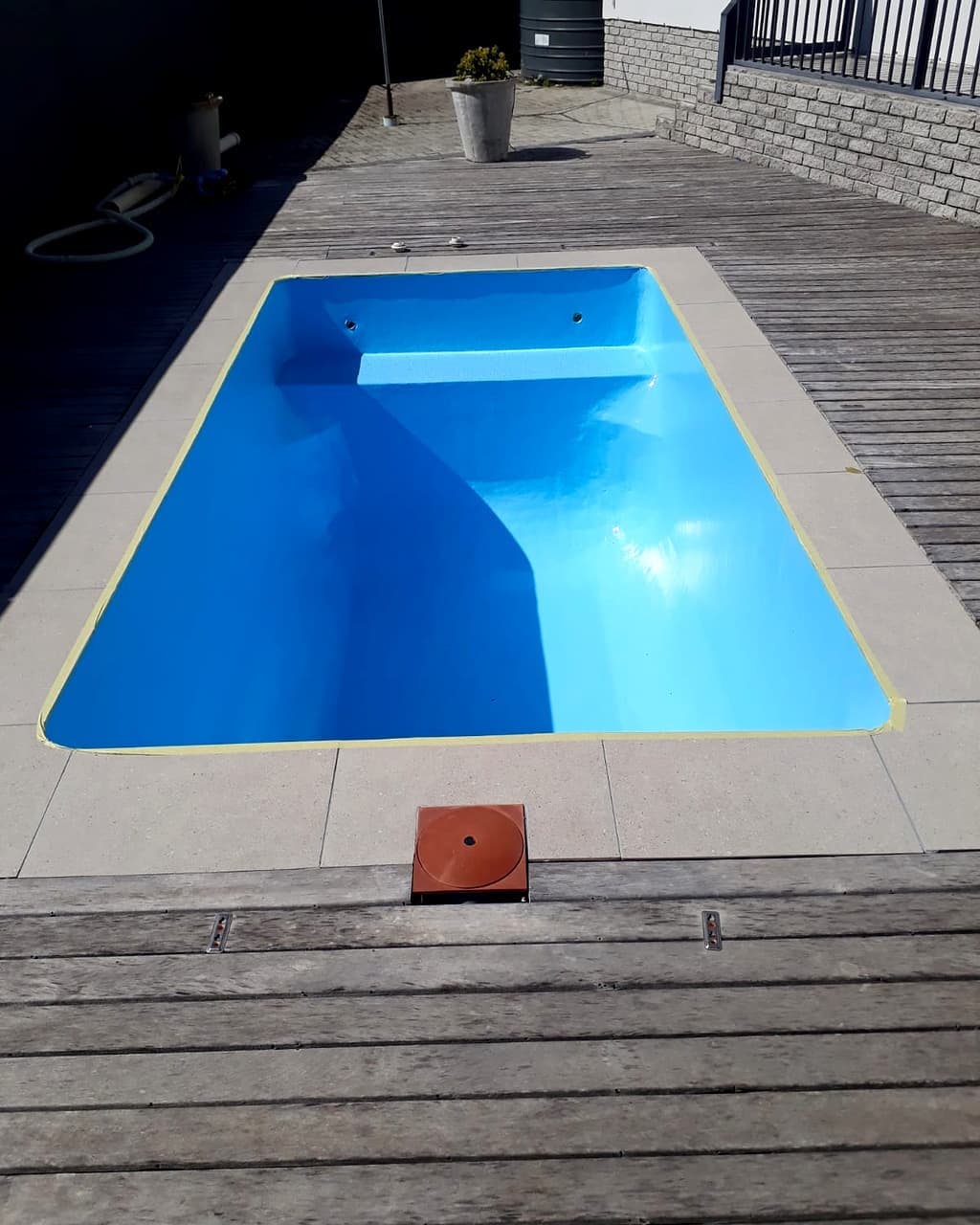 A finished pool repaint, refilled with clear pale blue water