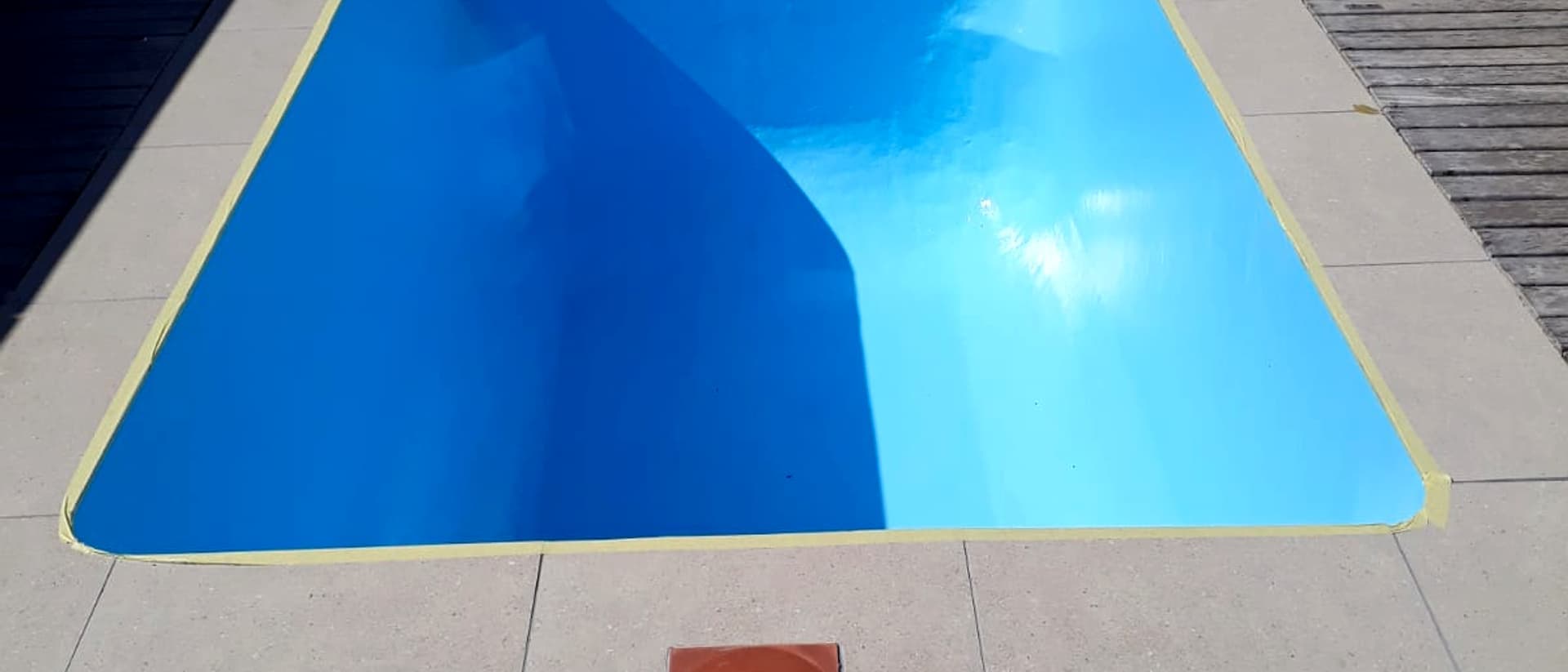 A freshly painted pool in pale blue, refilled and ready to swim