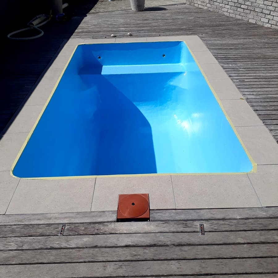 A freshly painted pool in pale blue, refilled and ready to swim